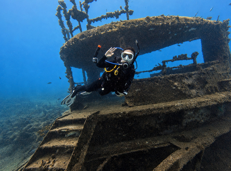 Scuba diver exploring the Atlantic Princess wreck in Bayahibe