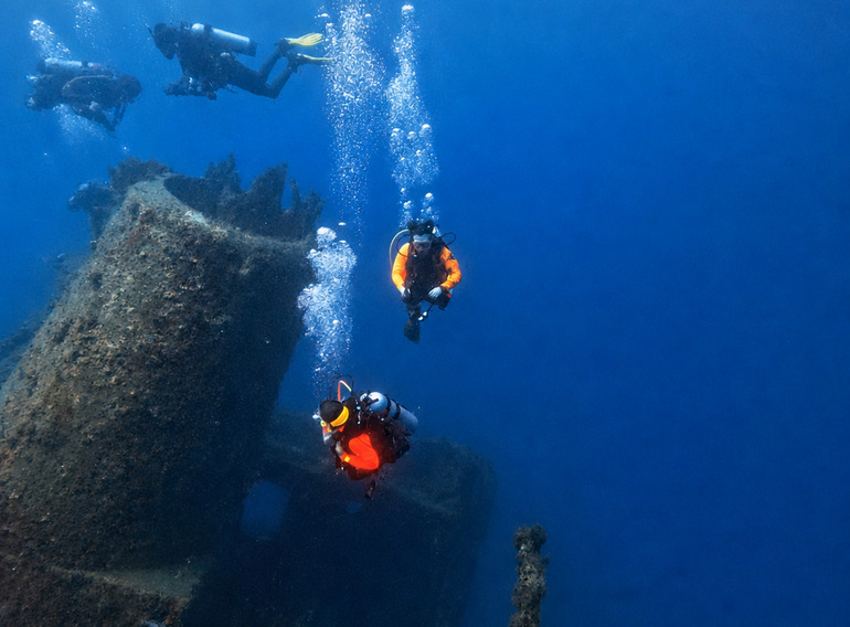 Scuba divers descending beside the St. George wreck in Bayahibe