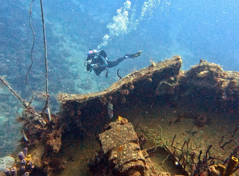 Diver maintaining controlled buoyancy above a wreck during recreational deep-diving training