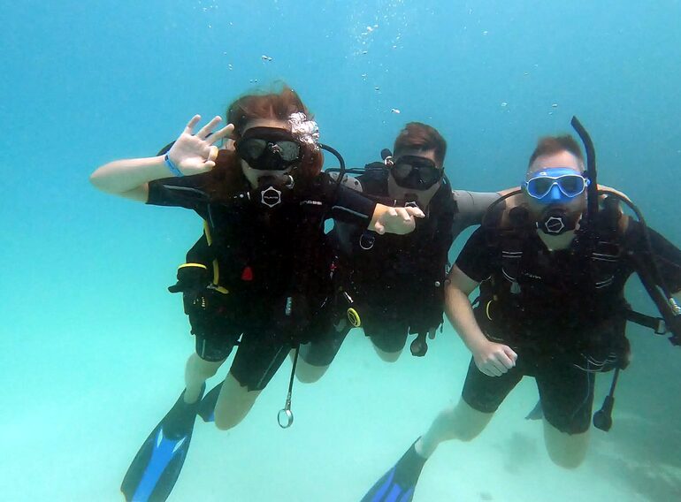 Divemaster candidate supporting divers during professional training in the Caribbean Sea near Bayahibe