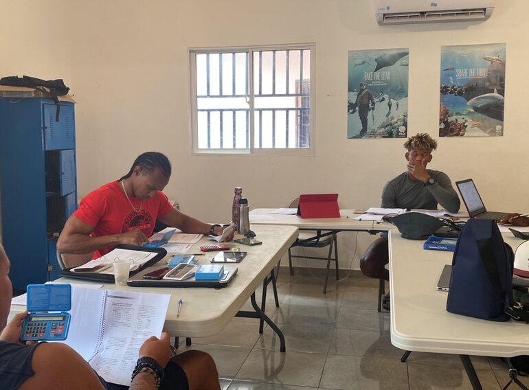Dive instructor candidates studying course standards, theory and teaching methods in the classroom