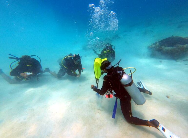 Instructor candidate evaluating student-diver skills during an underwater teaching presentation