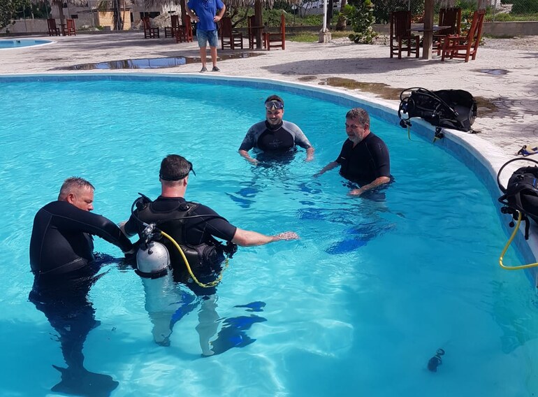 Open Water Diver students practising scuba skills in a pool with an instructor