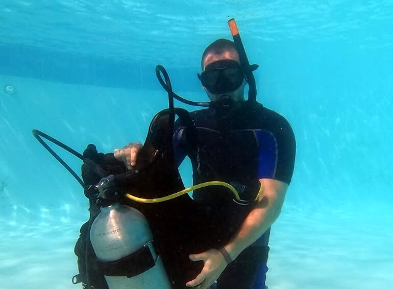 Open Water Diver student practising scuba equipment and safety skills with an instructor in confined water