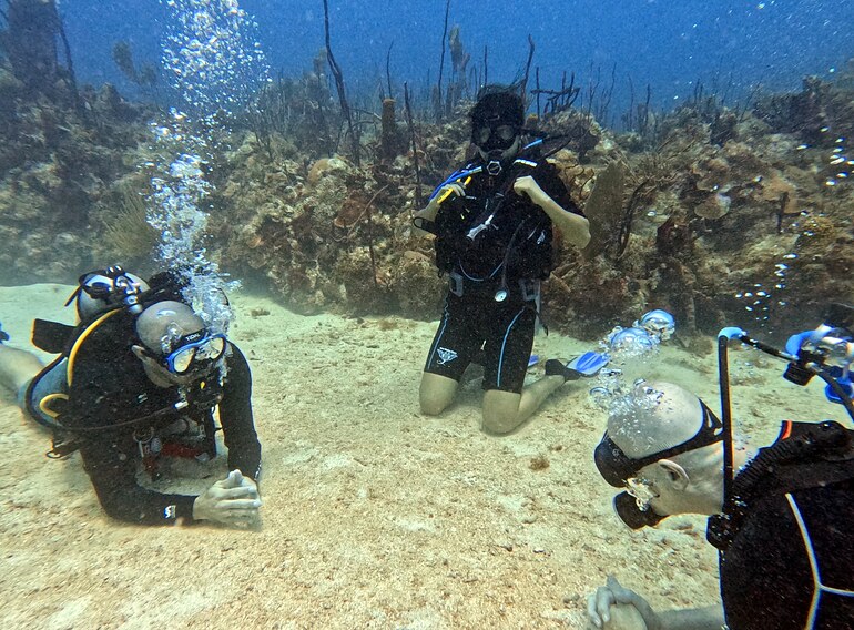 Open Water Diver students completing skills with an instructor during a Caribbean Sea training dive in Bayahibe