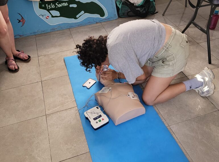 Emergency First Response student practising CPR and AED procedures on a training mannequin