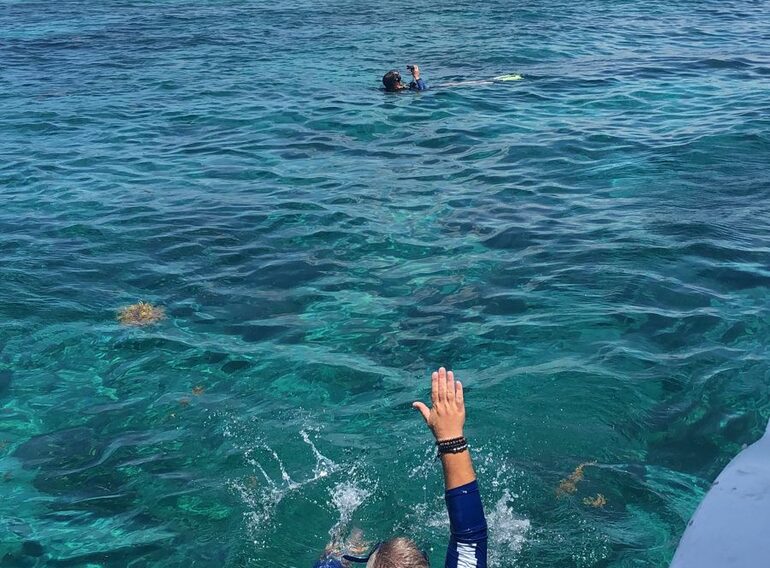 Rescue Diver student approaching and signalling to a diver during a Caribbean Sea surface exercise