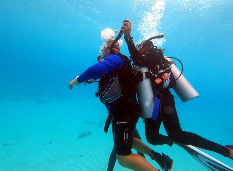 Rescue Diver students practising how to assist an unresponsive diver underwater near Bayahibe