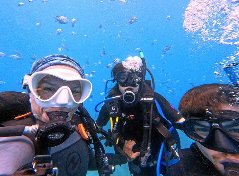 Family of scuba divers together underwater in the Caribbean Sea