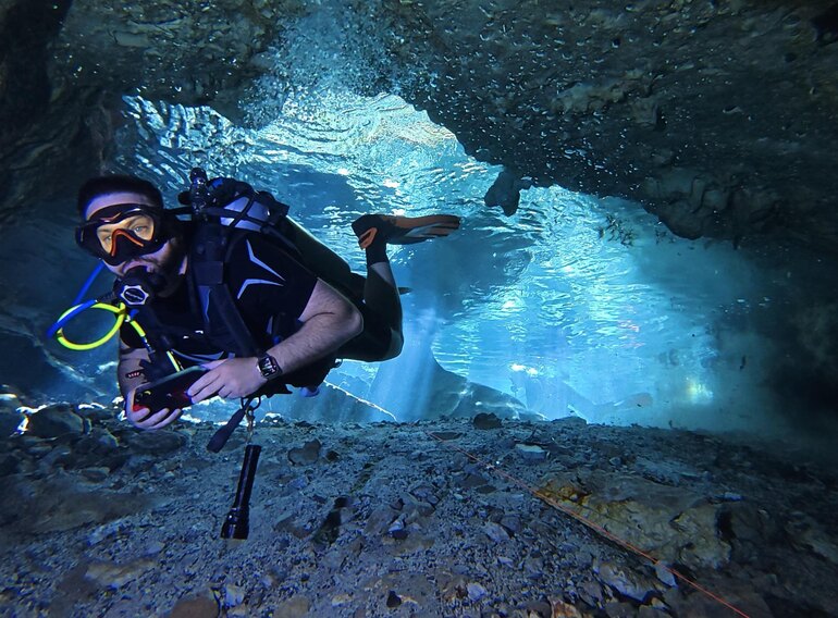 Scuba diver exploring a clear freshwater cavern in the Dominican Republic