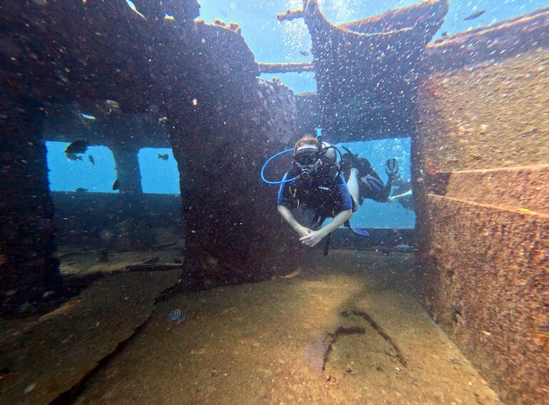 Diver exploring the interior structure of a Caribbean shipwreck during wreck training